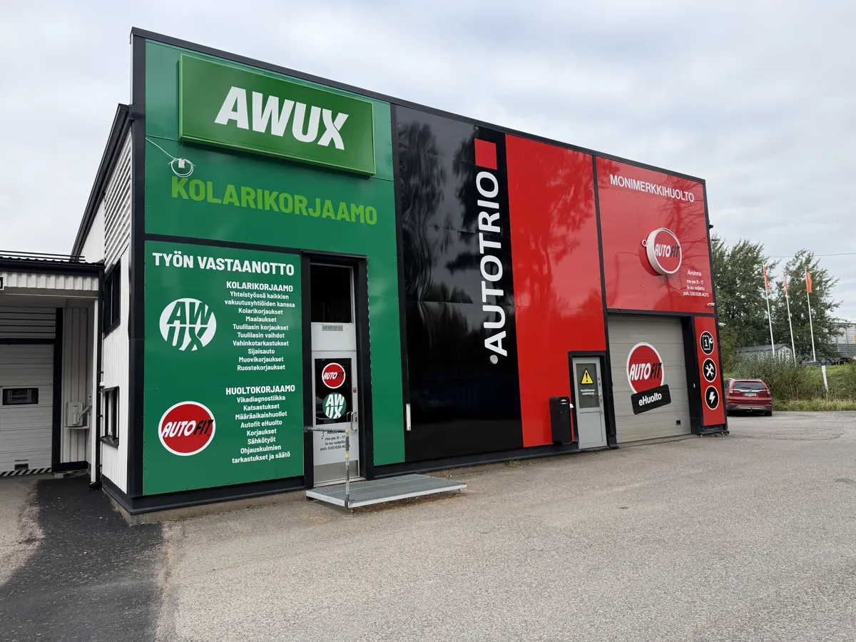 Awux-kolarikorjaamon vihreä julkisivu ja työn vastaanoton ovi Autotrion hallissa.