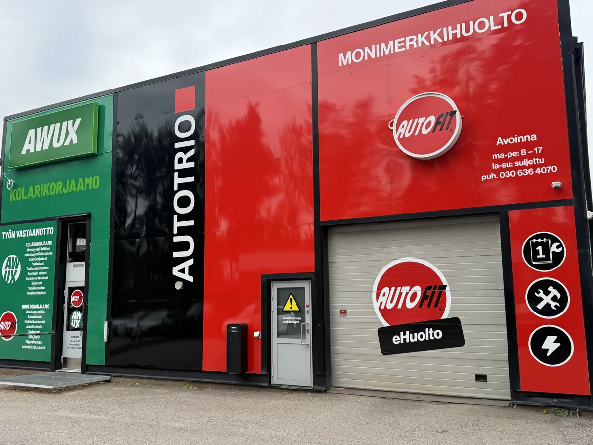 Autofit-monimerkkihuollon punainen julkisivu ja eHuolto-nosto-ovi Autotrion hallissa.